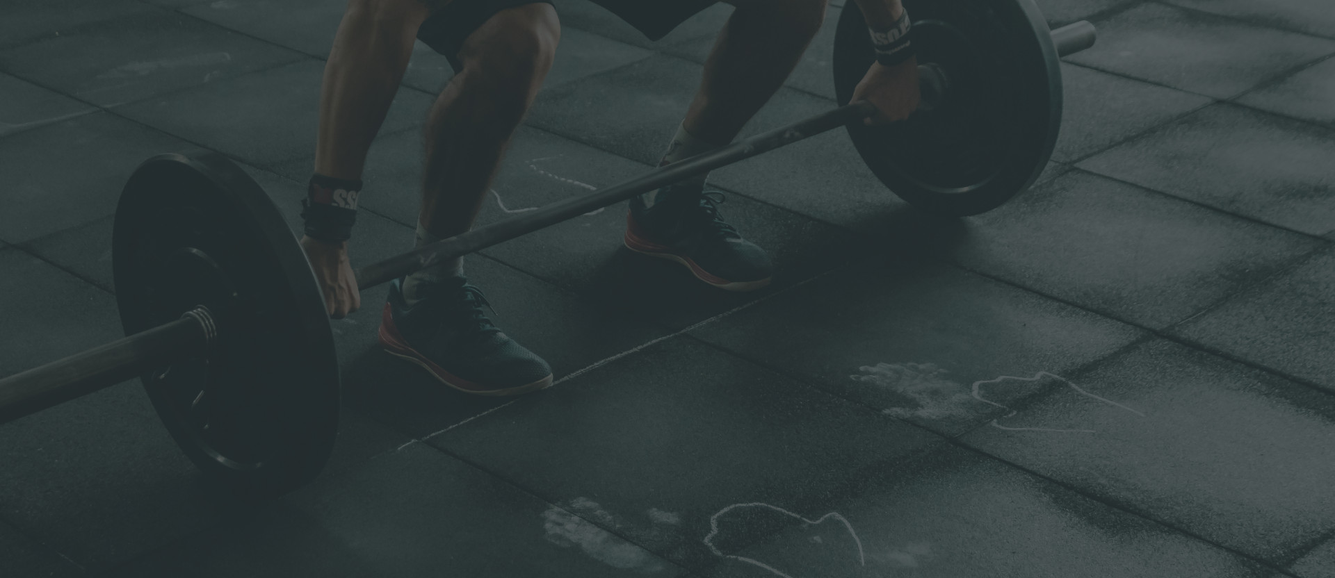 Athlete lifting a barbell in a dimly lit gym Athlete lifting a barbell in a dimly lit gym