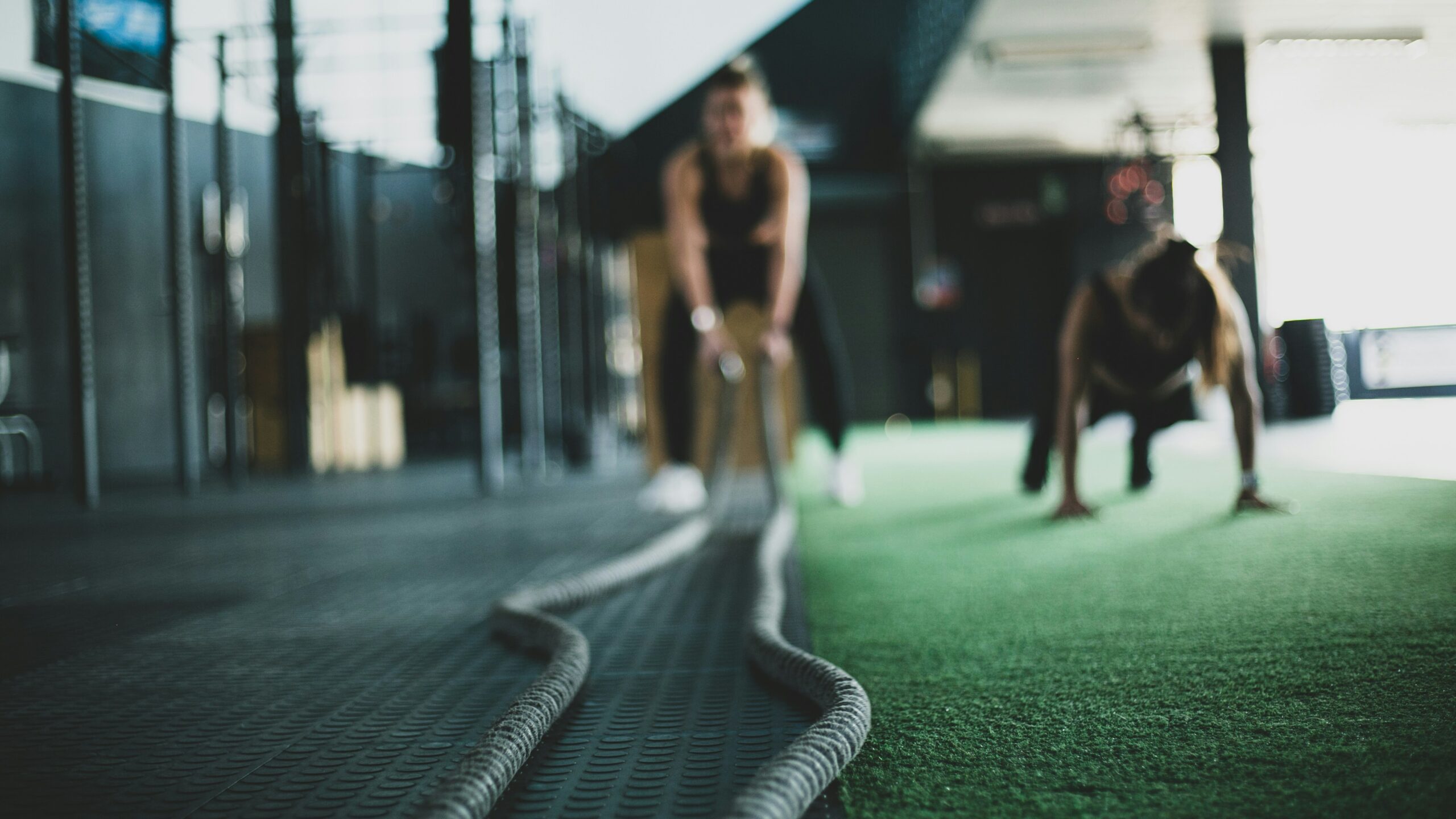 Athletes training with battle ropes in a gym