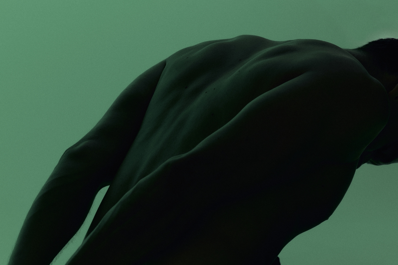 Silhouette of a person's bare back and shoulder Silhouette of a person's bare back and shoulder
