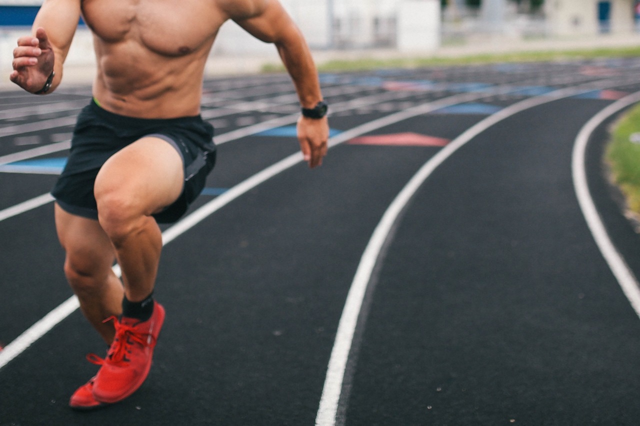 Runner in shorts and trainers on an outdoor athletics track