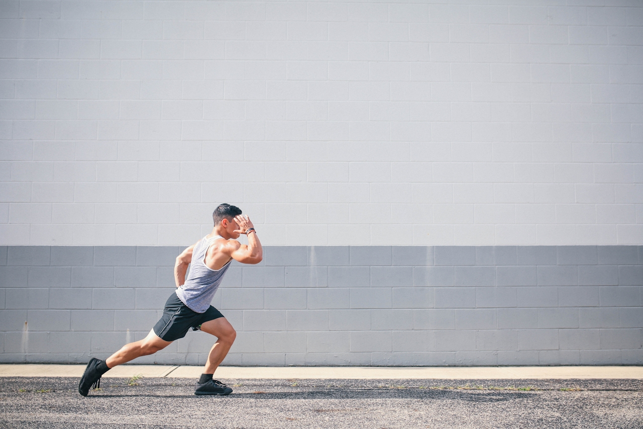 Athlete performing a sprint drill against a wall outdoors Athlete performing a sprint drill against a wall outdoors